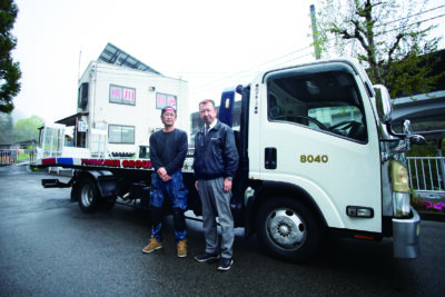 積載車の前に立つ山口社長（右）と金澤さん