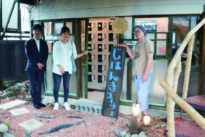 壁を抜いて作った入口の前に立つ久保田さん、まちつくり青梅の田中志緒利さん、栗島健さん（右から）