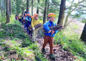 登山帰りに薪を運ぶ園児ら